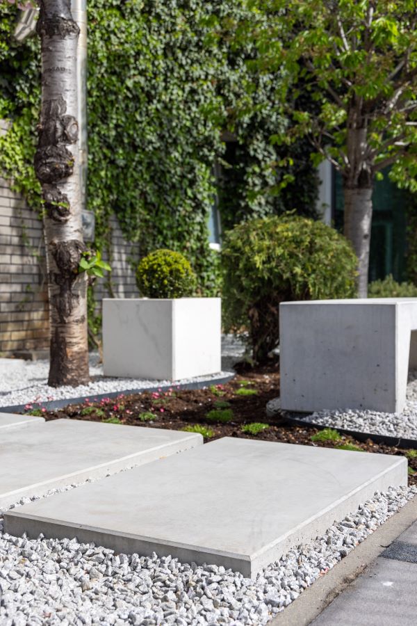 Ścieżka z betonowych płyt Stella, obok betonowa donica Cubo i fragment ławki